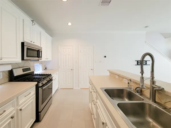 a kitchen with granite countertop a sink and a stove top oven