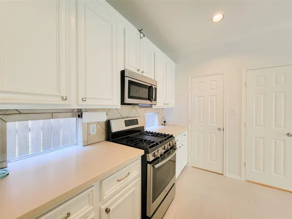 a kitchen with white cabinets and black appliances