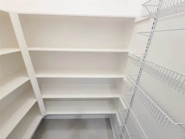 a view of walk in closet with empty racks