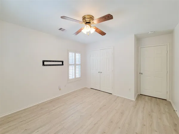 an empty room with a window and a ceiling fan