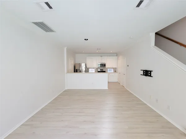 a view of a kitchen with wooden floor and electronic appliances