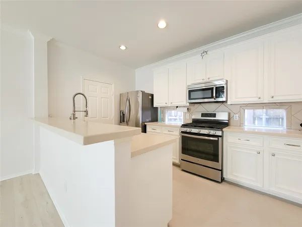 a kitchen with kitchen island a sink appliances and cabinets