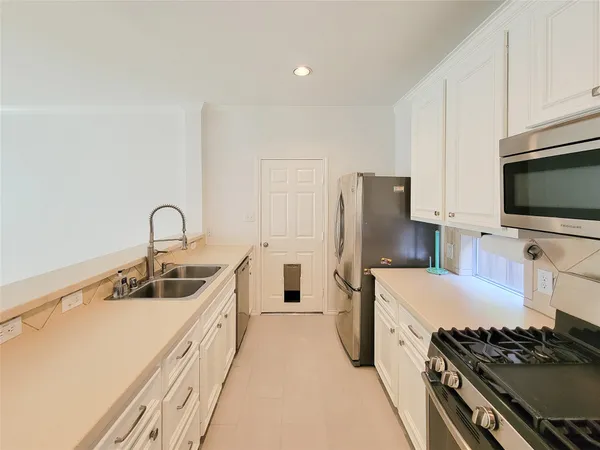 a kitchen that has a sink and a stove top oven