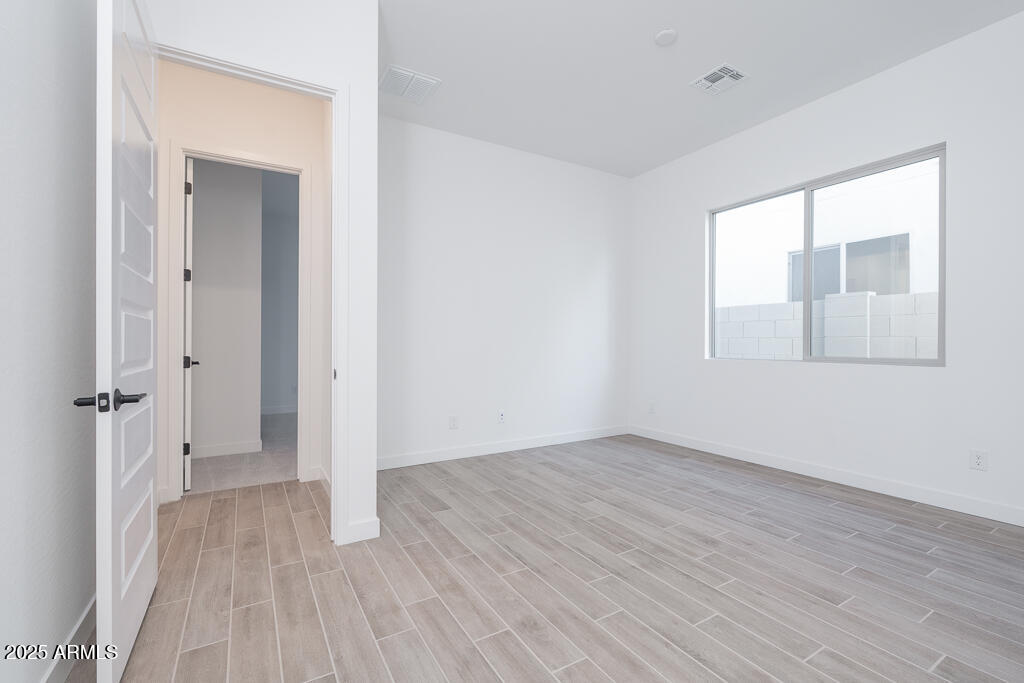 1946 East Empeltre Road San Tan Valley, AZ 85140 - Photo 11 of 19 a view of an empty room with wooden floor and a window
