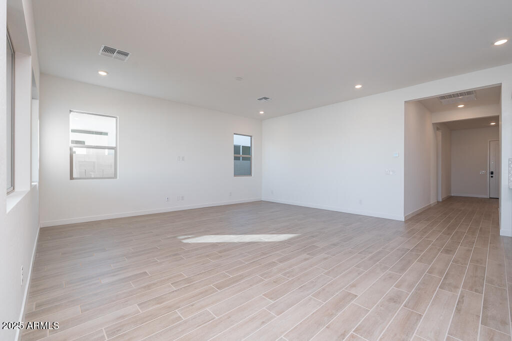 1946 East Empeltre Road San Tan Valley, AZ 85140 - Photo 4 of 19 an empty room with wooden floor and windows