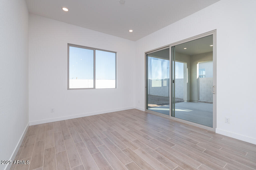1946 East Empeltre Road San Tan Valley, AZ 85140 - Photo 5 of 19 an empty room with wooden floor and mirror