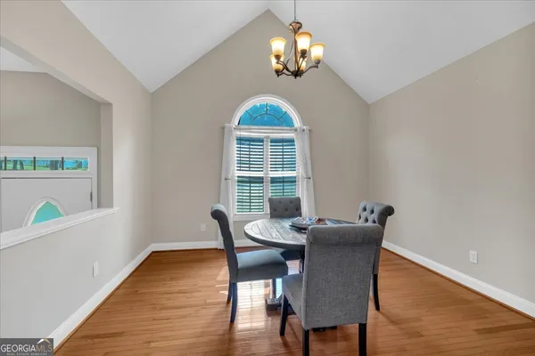 a dining room with furniture a chandelier and wooden floor
