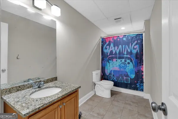 a bathroom with a granite countertop sink a toilet and a mirror