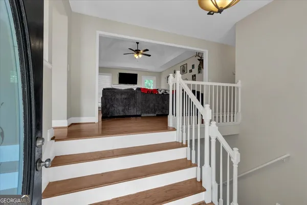 a living room with a ceiling fan and a rug