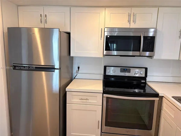 a kitchen with stainless steel appliances white cabinets and a stove