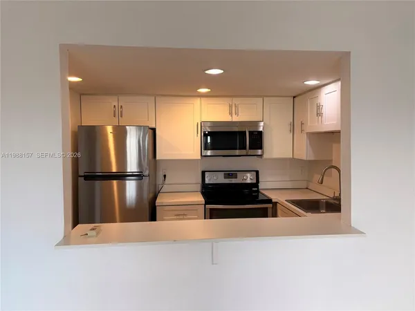a kitchen with stainless steel appliances a refrigerator and a stove top oven