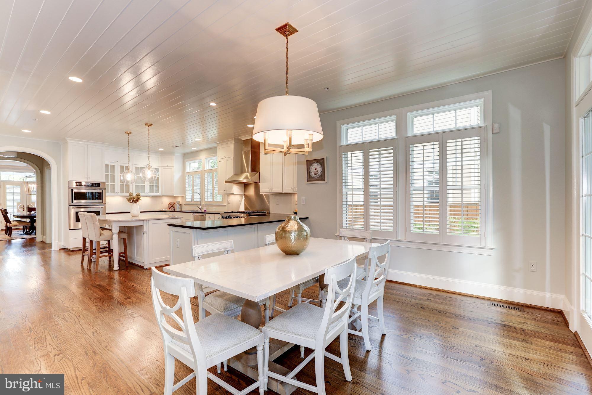 7003 Brookville Road Chevy Chase, MD 20815 - Photo 14 of 30 a dining room with wooden floor a chandelier a wooden table and chairs