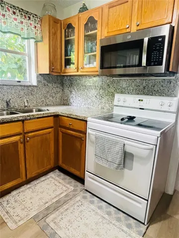 a kitchen with stainless steel appliances granite countertop a sink and a microwave