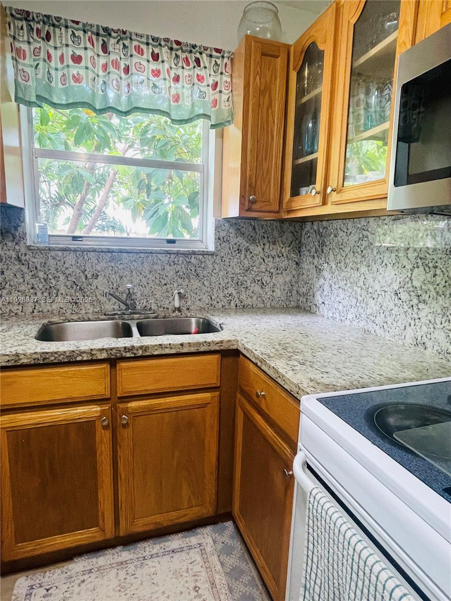 2045 Northwest 34th Street Miami, FL 33142 - Photo 7 of 12 a kitchen with stainless steel appliances granite countertop a sink and a microwave