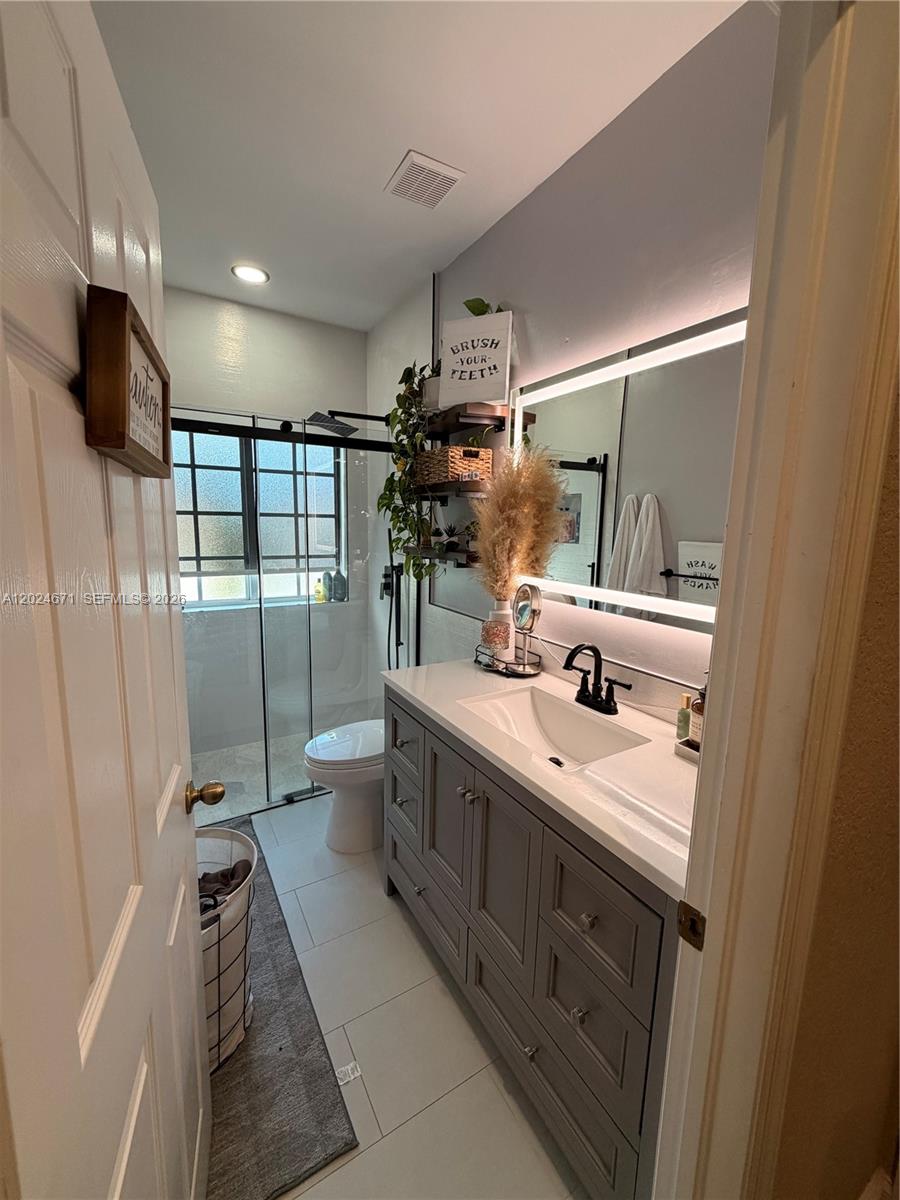 2116 Northeast 38th Road, Unit 2116 Homestead, FL 33033 - Photo 13 of 31 a bathroom with a double vanity sink and mirror
