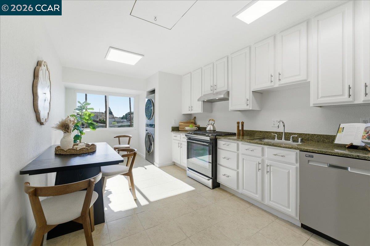 4740 Appian Way, Unit 9 El Sobrante, CA 94803 - Photo 10 of 23 a kitchen with stainless steel appliances granite countertop a stove top oven a sink a dining table and chairs with white cabinets