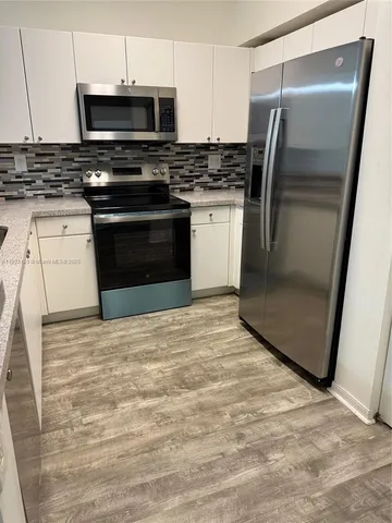 a kitchen with stainless steel appliances granite countertop a stove a refrigerator and a stove