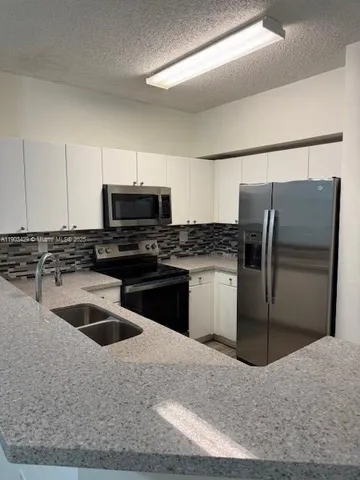 a kitchen with a refrigerator sink and microwave