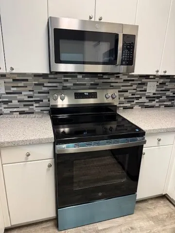 a stove top oven sitting inside of a kitchen