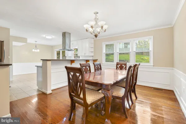 a view of a dining room with furniture a chandelier and wooden floor