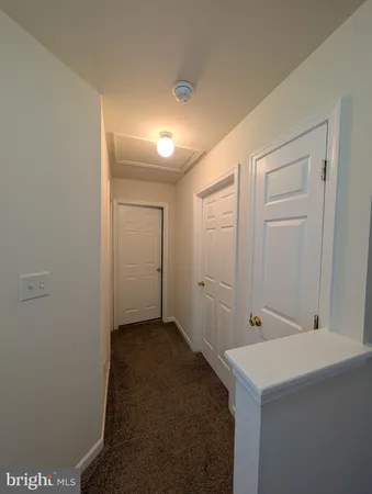 a view of a hallway with wooden floor and stairs