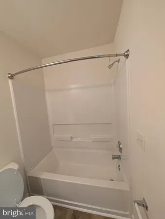 a bathroom with a granite countertop toilet sink and mirror