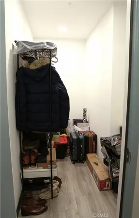 a view of walk in closet with clothes and shoes