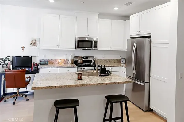 a kitchen with stainless steel appliances granite countertop a refrigerator sink and cabinets