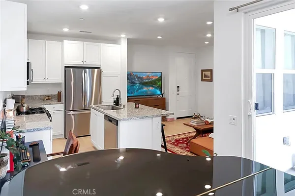 a kitchen with stainless steel appliances granite countertop a refrigerator and a stove top oven