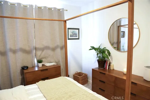 a bedroom with a bed table and a potted plant