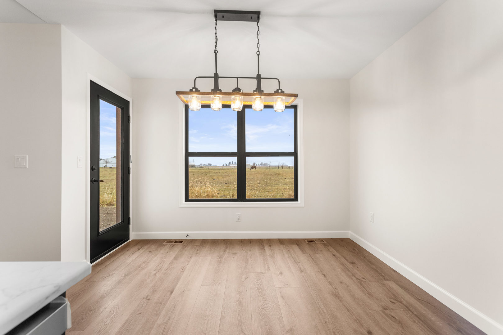 513 Patterson Drive Fisher, IL 61843 - Photo 9 of 25 an empty room with wooden floor and windows