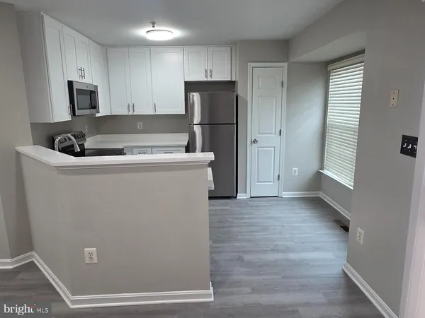 a kitchen with a refrigerator sink and cabinets