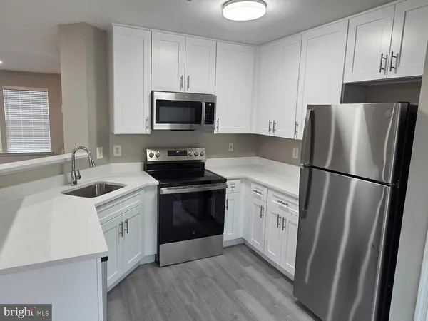 a kitchen with white cabinets sink and stainless steel appliances