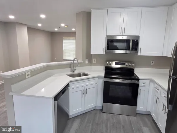 a kitchen with white cabinets stainless steel appliances and sink
