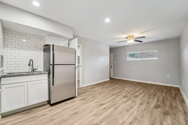 a kitchen with granite countertop a refrigerator and a sink