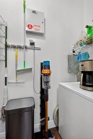 a utility room with dryer washer and a view of living room