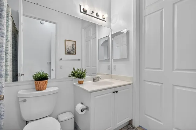 a bathroom with a toilet a sink and a mirror