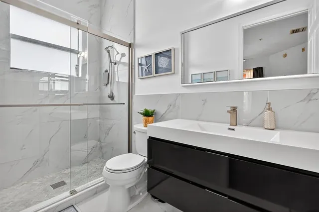 a bathroom with a sink a toilet and shower