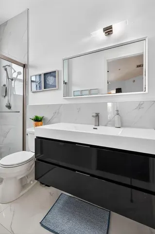 a bathroom with a sink toilet and mirror