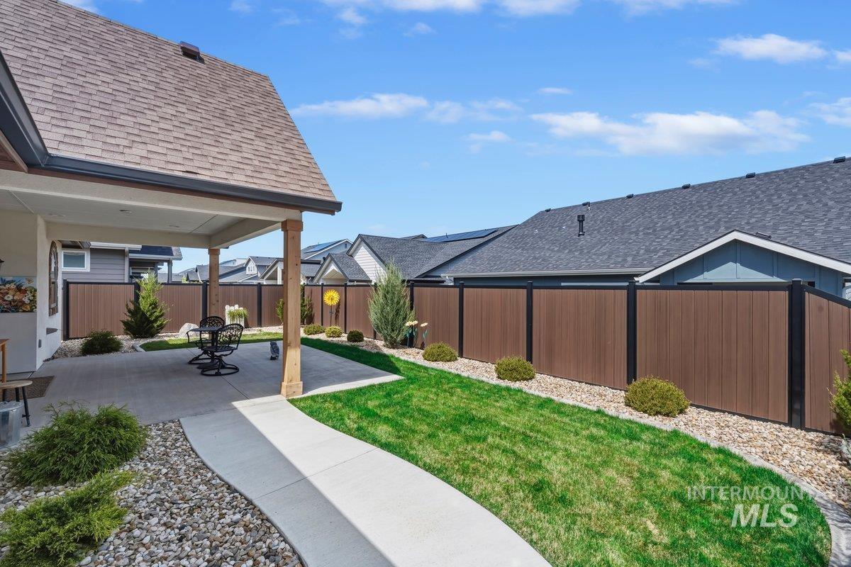 2016 East Mainacht Street Meridian, ID 83642 - Photo 34 of 36 Stucco and stone exterior featuring a gabled roof, an attached two-car garage with an arched window accent, and a paved driveway