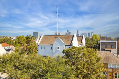 a view of a house with a big yard and large tree