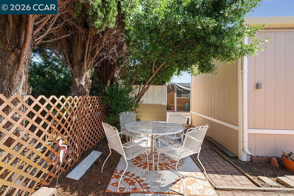 3301 Buchanan Road Antioch, CA 94509 - Photo 19 of 26 a view of a patio with table and chairs with wooden fence and large trees