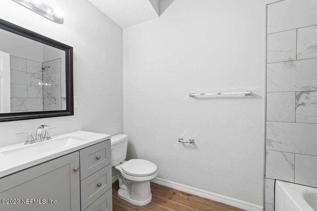 11816 Lem Turner Road Jacksonville, FL 32218 - Photo 16 of 24 a bathroom with a toilet a sink a vanity and mirror
