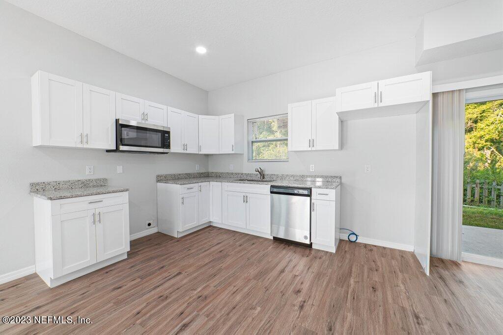 11816 Lem Turner Road Jacksonville, FL 32218 - Photo 7 of 24 a kitchen with granite countertop white cabinets and white appliances