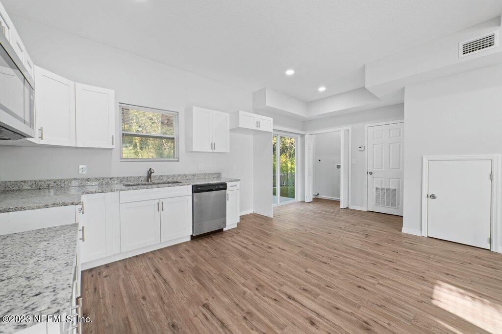11816 Lem Turner Road Jacksonville, FL 32218 - Photo 8 of 24 a large kitchen with a wooden floor and stainless steel appliances