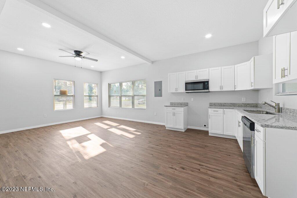 11816 Lem Turner Road Jacksonville, FL 32218 - Photo 10 of 24 a open kitchen with granite countertop a stove top oven a sink dishwasher and a refrigerator with wooden floor