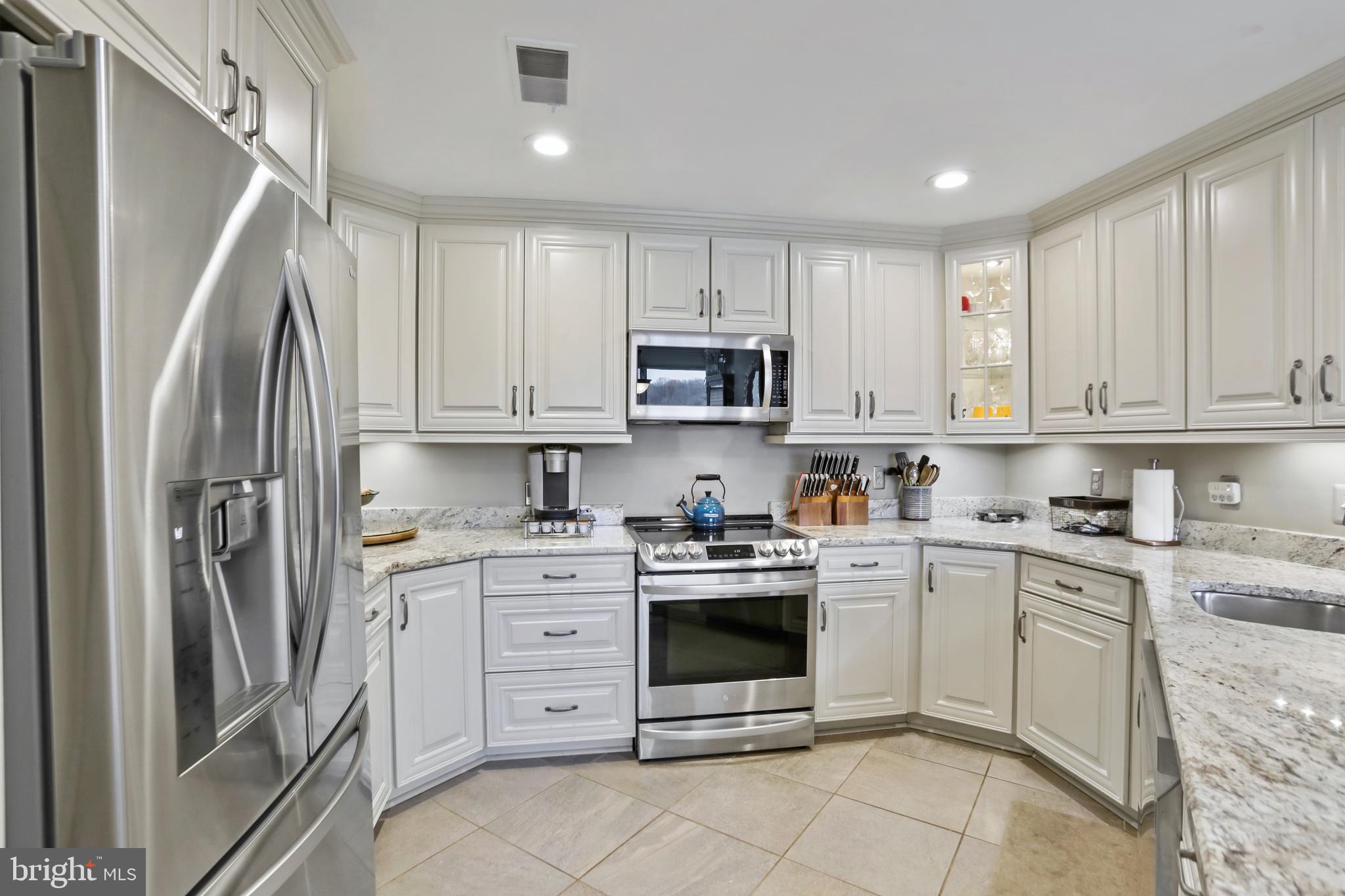 11218 Harbor Court Reston, VA 20191 - Photo 13 of 39 a kitchen with stainless steel appliances granite countertop a refrigerator sink and cabinets