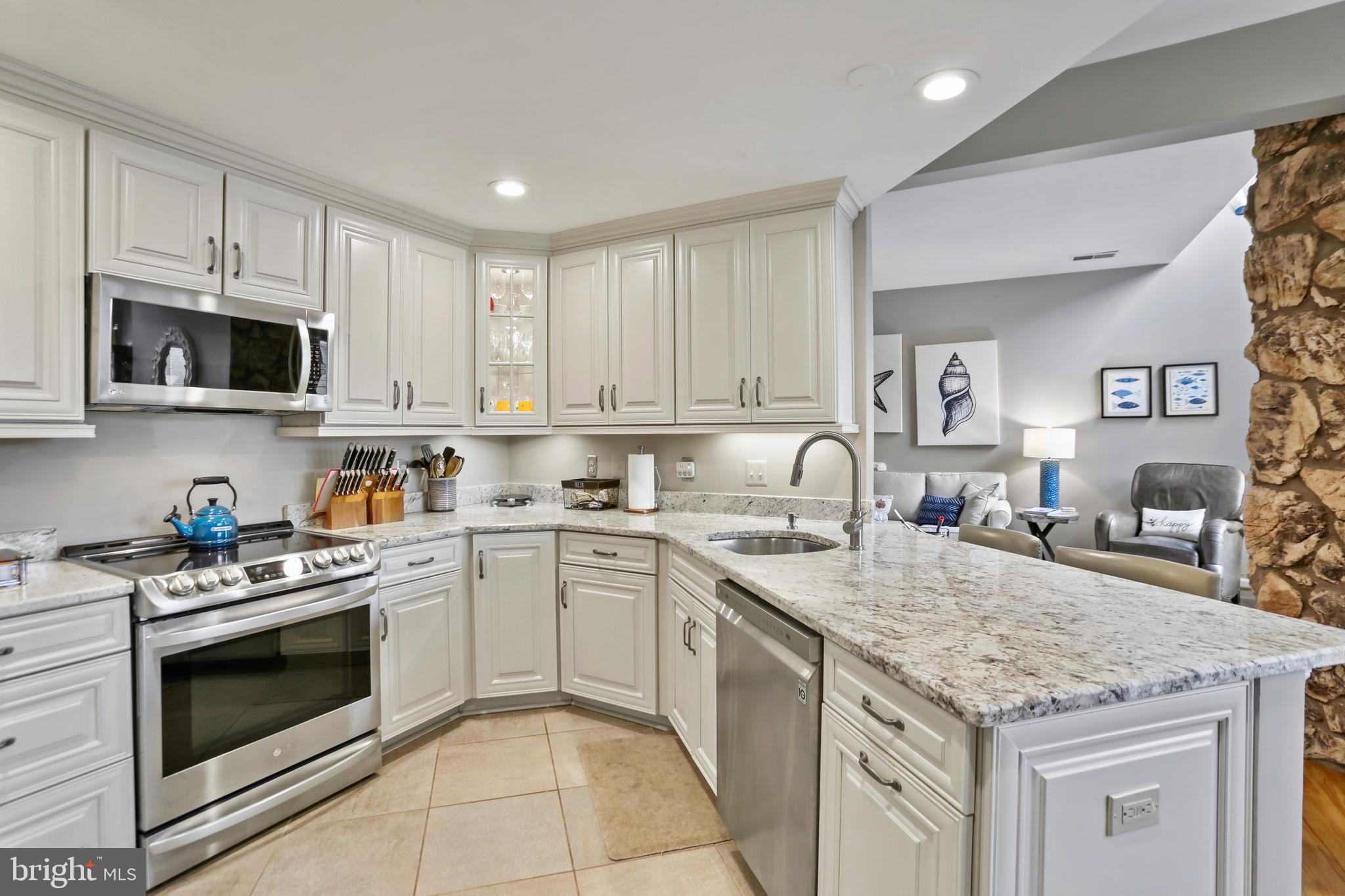 11218 Harbor Court Reston, VA 20191 - Photo 14 of 39 a kitchen with granite countertop a stove top oven sink and cabinets