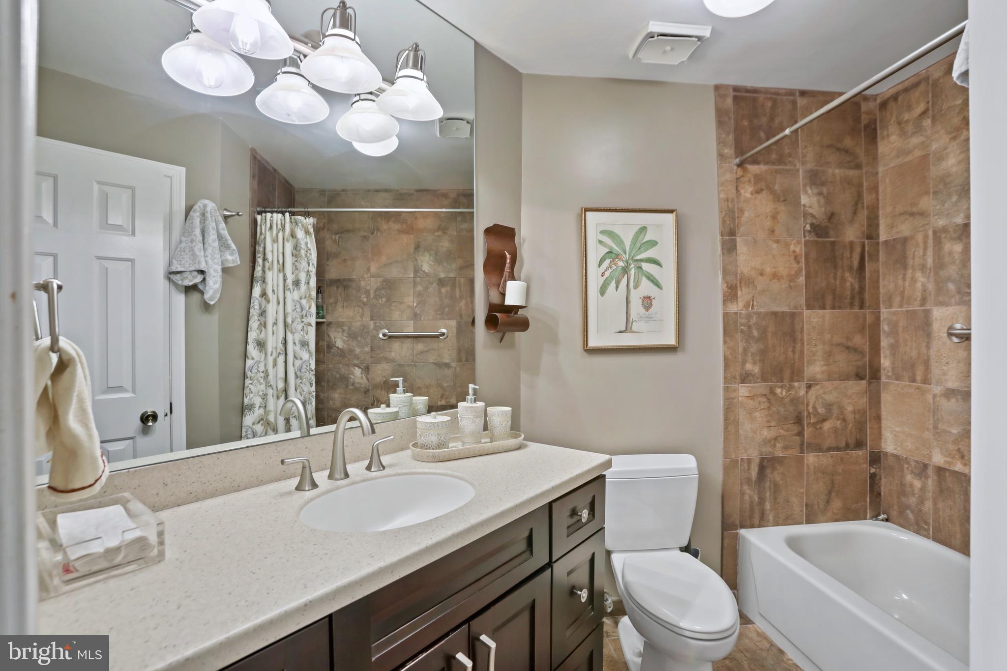 11218 Harbor Court Reston, VA 20191 - Photo 17 of 39 a bathroom with a sink a toilet a mirror a vanity and shower