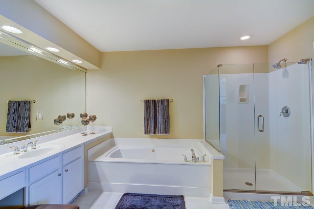 3902 Sunset Maple Court Raleigh, NC 27612 - Photo 13 of 21 a bathroom with a tub sink and mirror